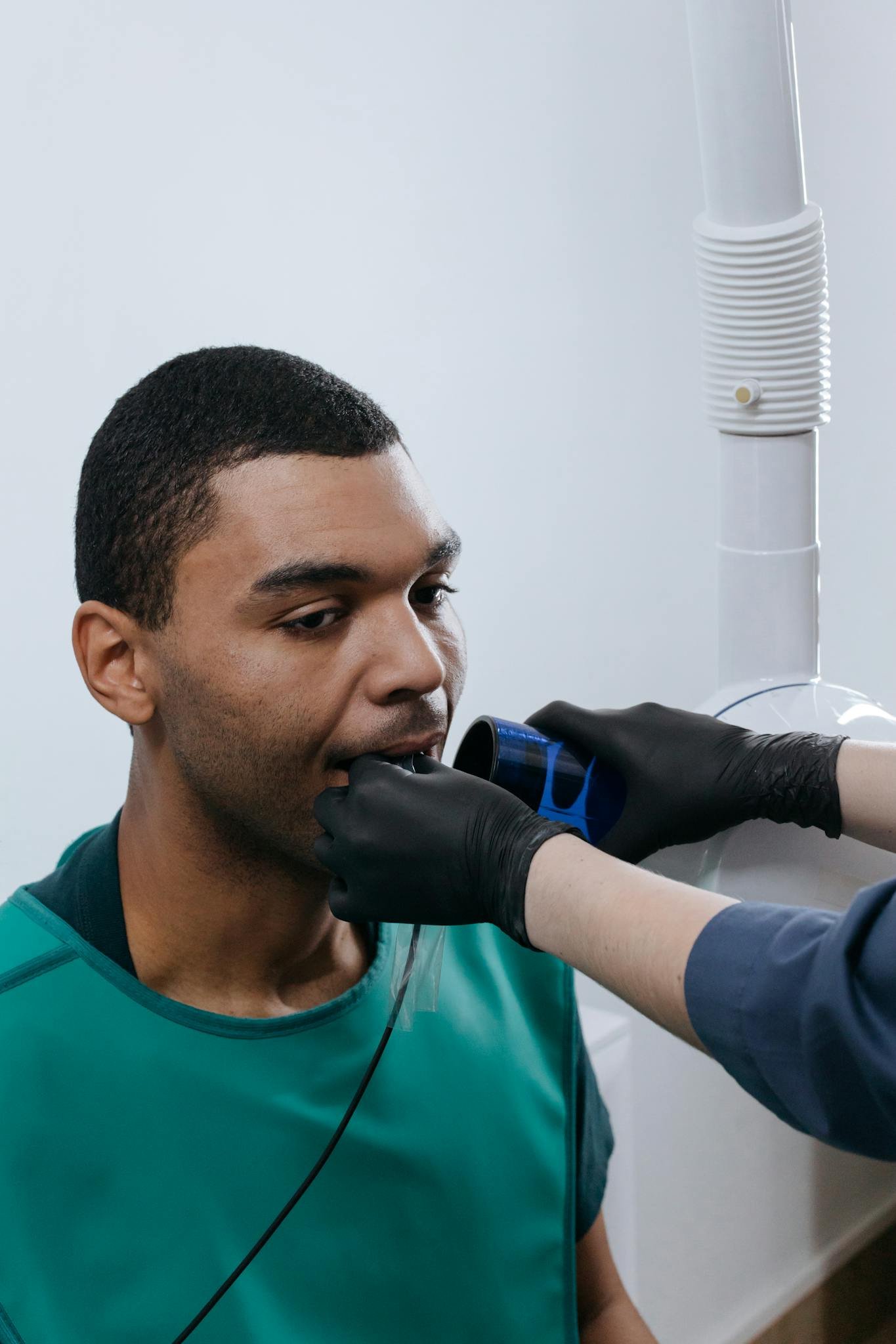 A patient undergoing a dental x-ray examination in a clinic setting.
