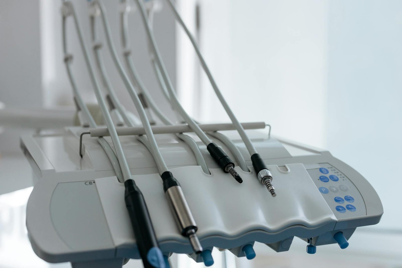 Close-up of modern dental equipment featuring cords and instruments in a clinic.